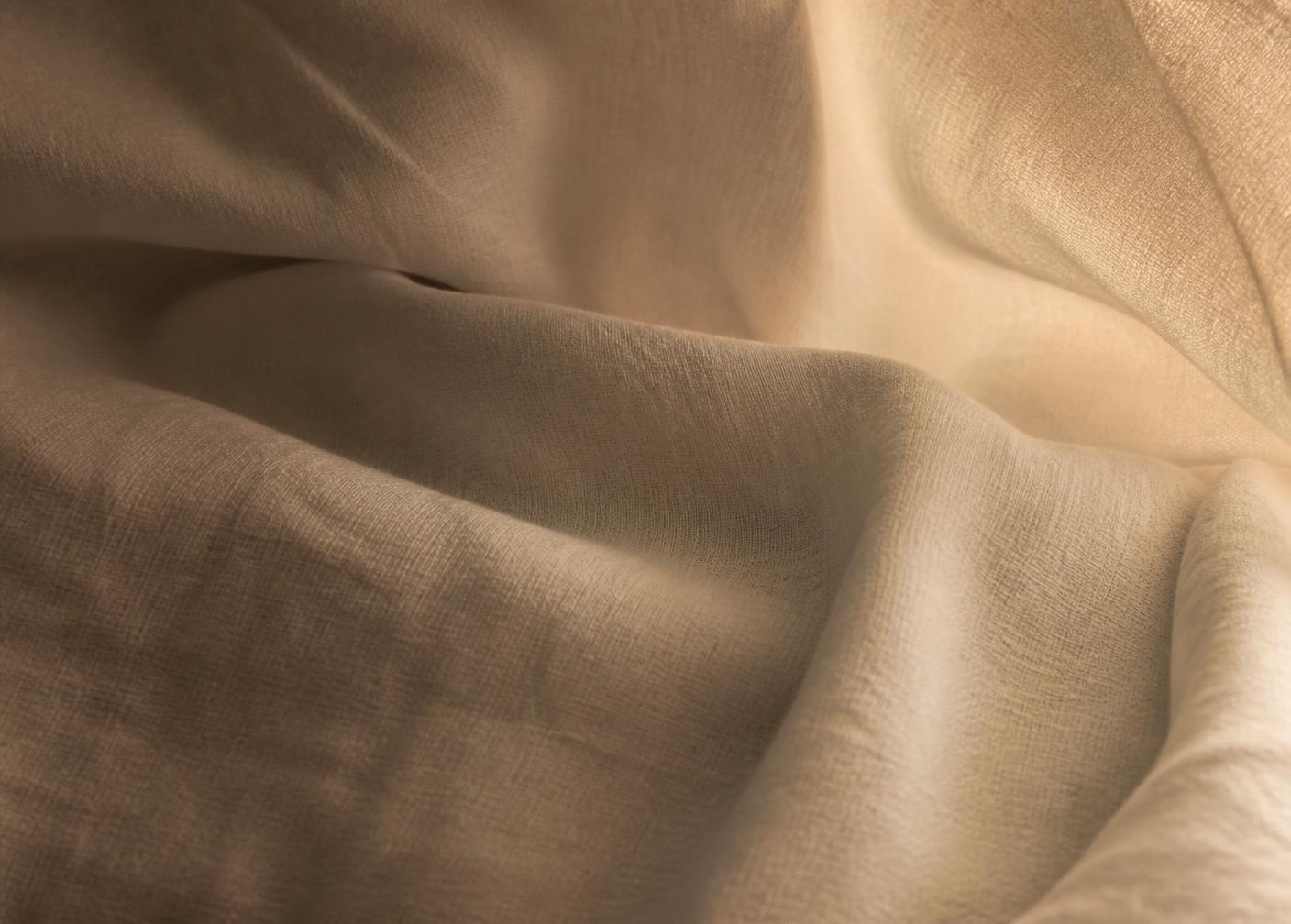 Soft folds of warm ivory linen in bronze light